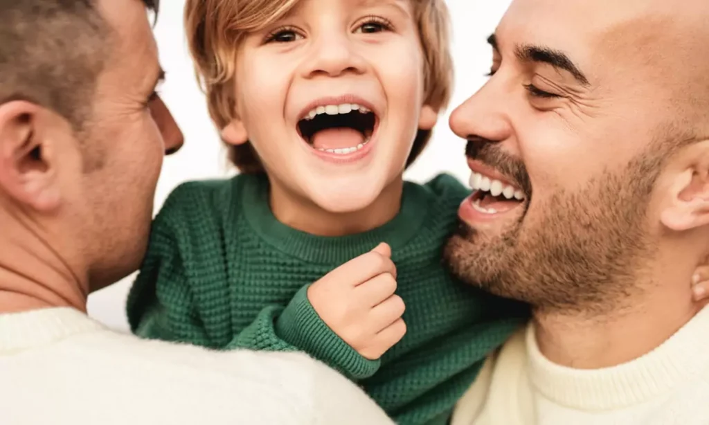 gay male couple having tender moment with boy outd