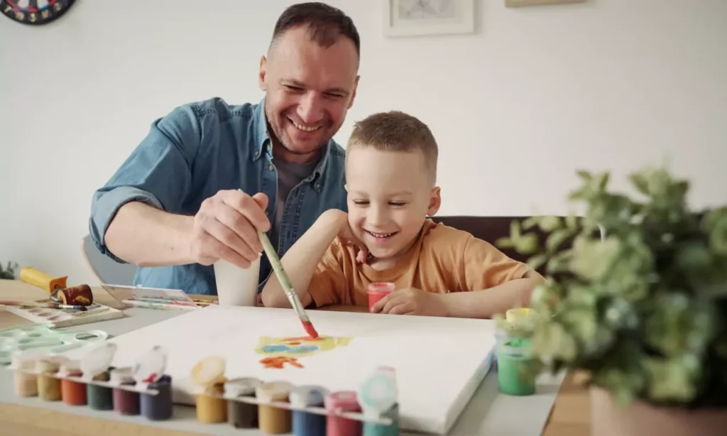 kid boy and dad painting together