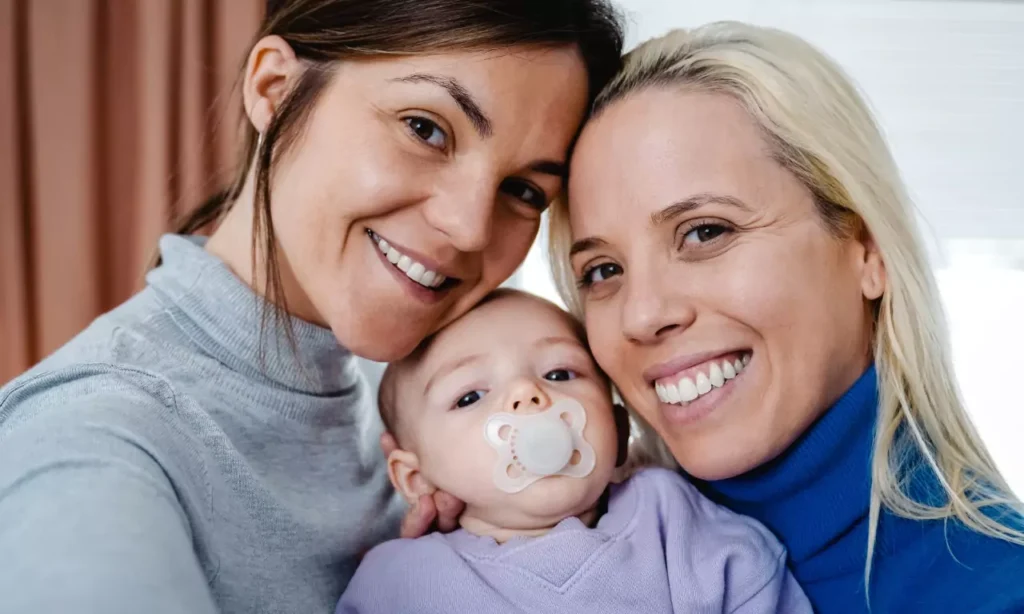gay lesbian couple and newborn baby taking selfie