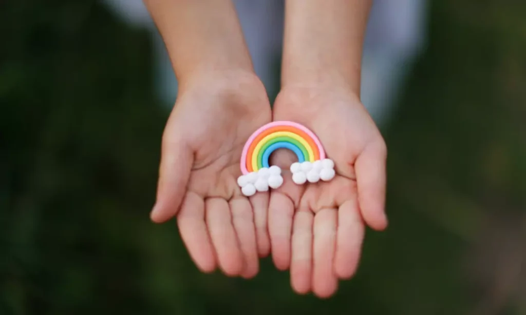 kids hands holds toy rainbow in his hands the con