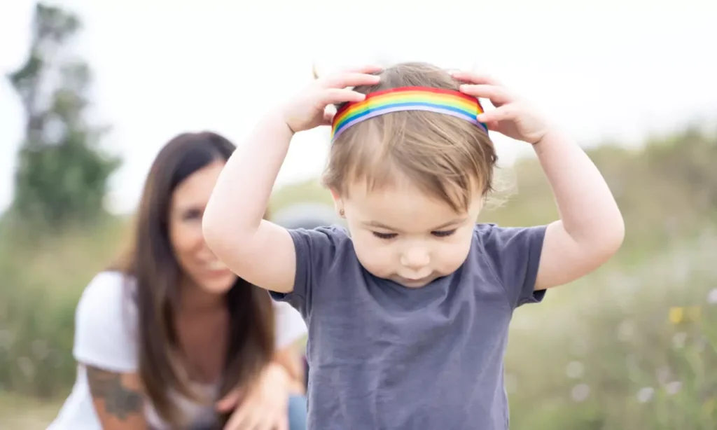 little girl playing with a lgbt headband outdoors